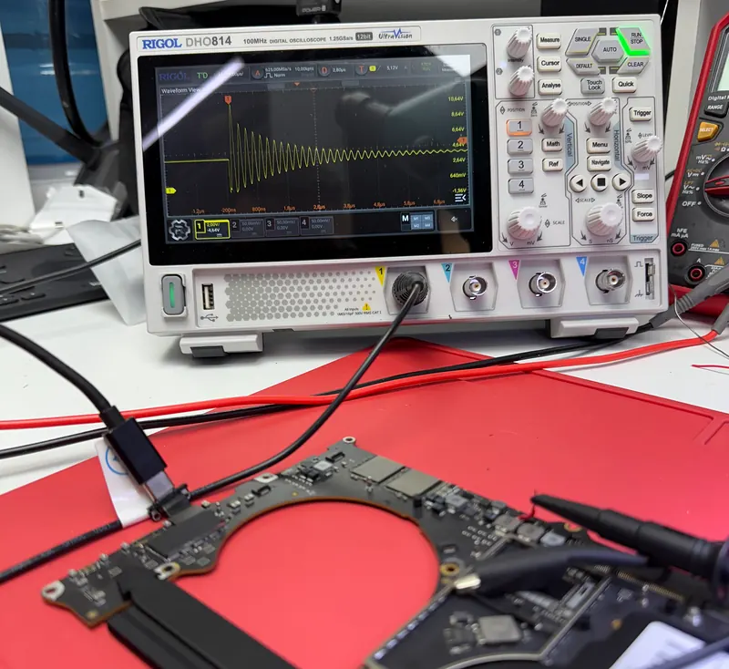 Osciloscopio midiendo una señal sobre una placa lógica conectada con puntas de prueba