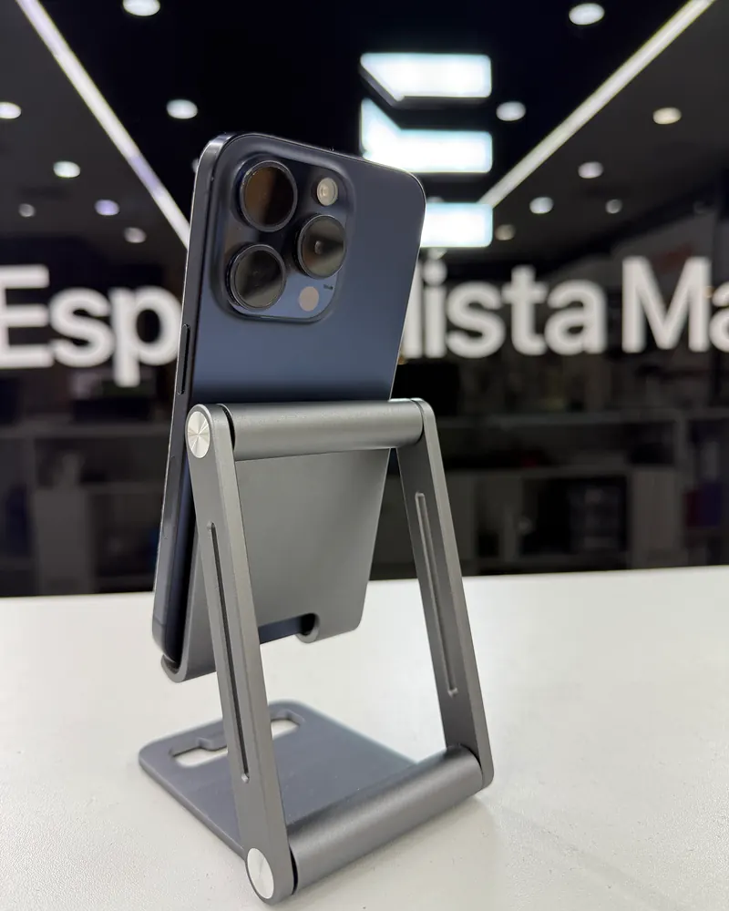 iPhone azul apoyado en un soporte metálico sobre el mostrador del local